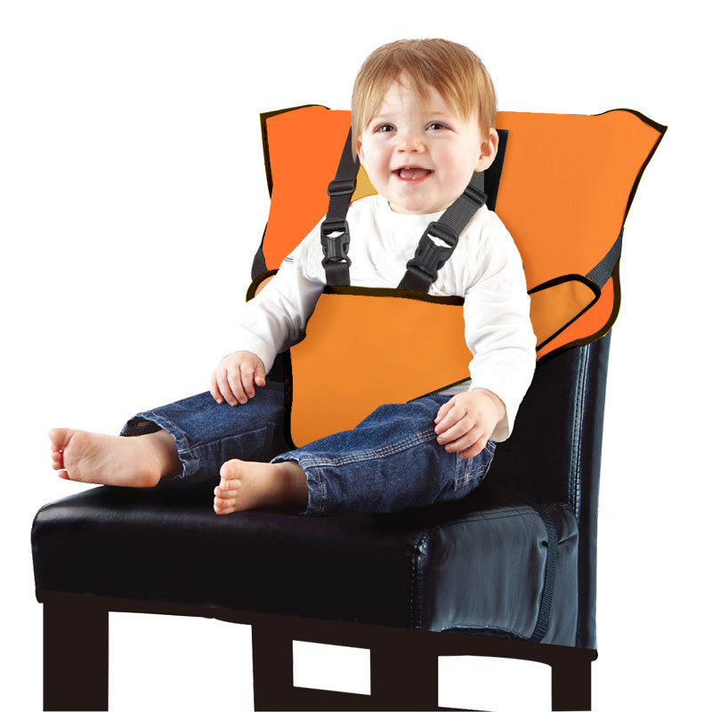 Child sitting in an orange safety seat on a black chair with a white background