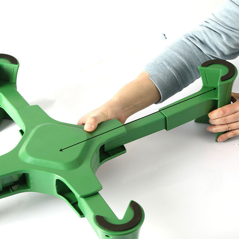 Green and black adjustable stand being held by a person on a white background