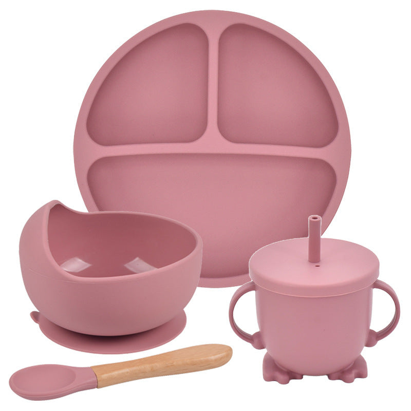 Pink children's dining set with plate, bowl, cup, and spoon on a white background
