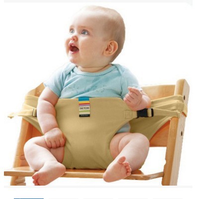 Baby sitting in a beige high chair with a white background