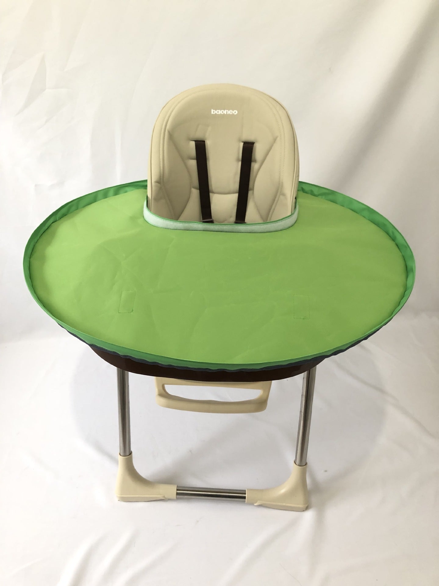 Green baby high chair with beige cushion on a white background