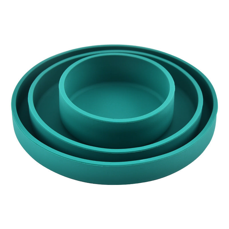 Set of three teal silicone dishes on a white background