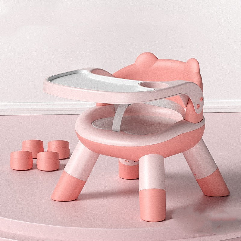 Pink and white children's chair with a small table on a light pink background