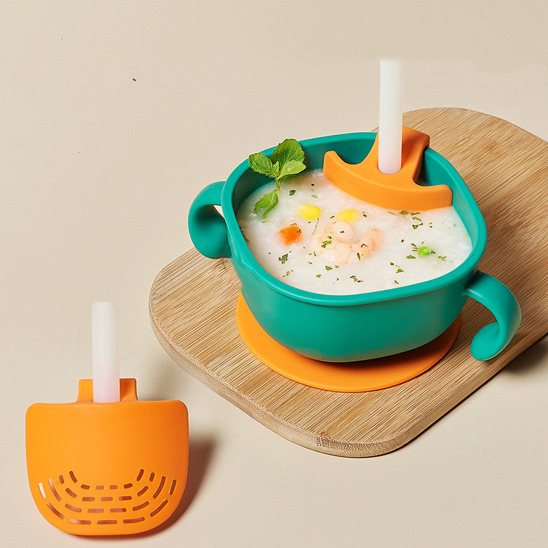 Children's bowl with spoon and straw on a wooden tray against a beige background