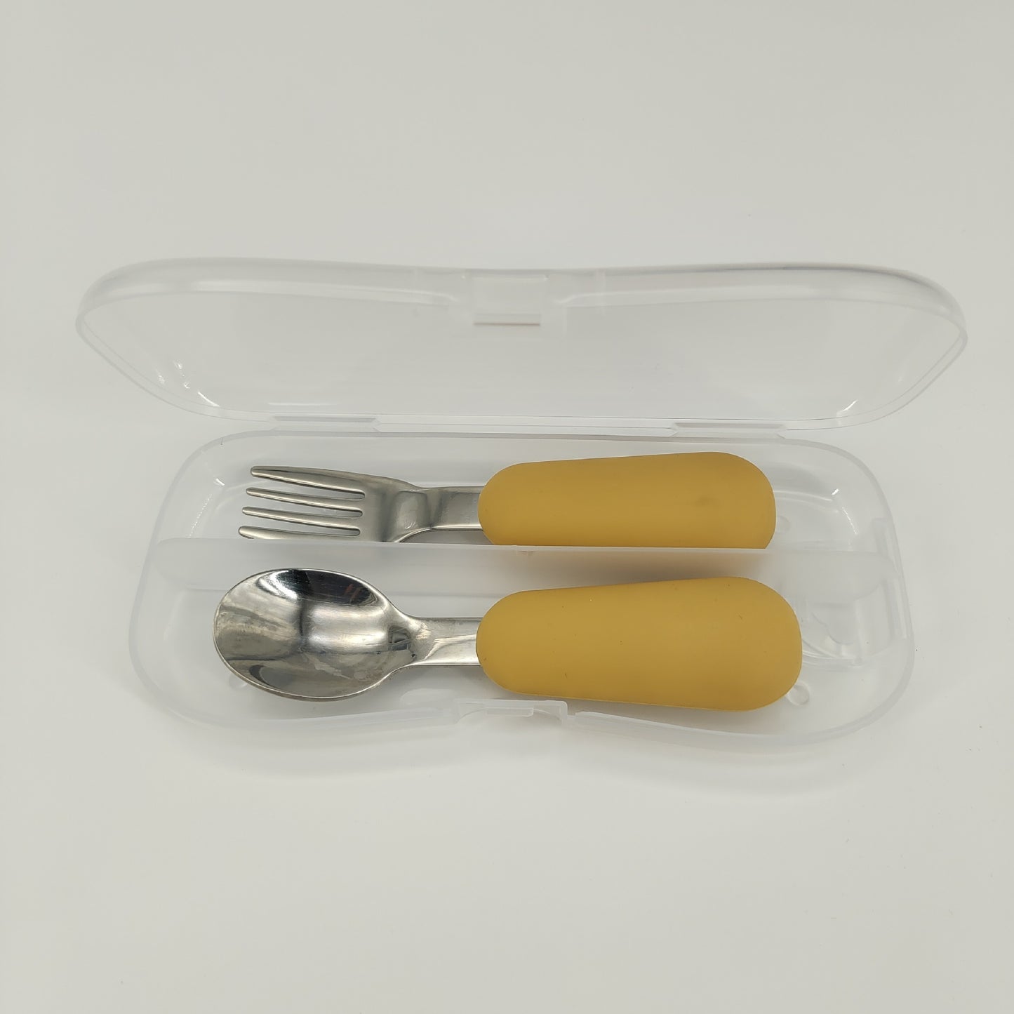 Set of silver fork and spoon with mustard yellow handles in a clear case on a white background