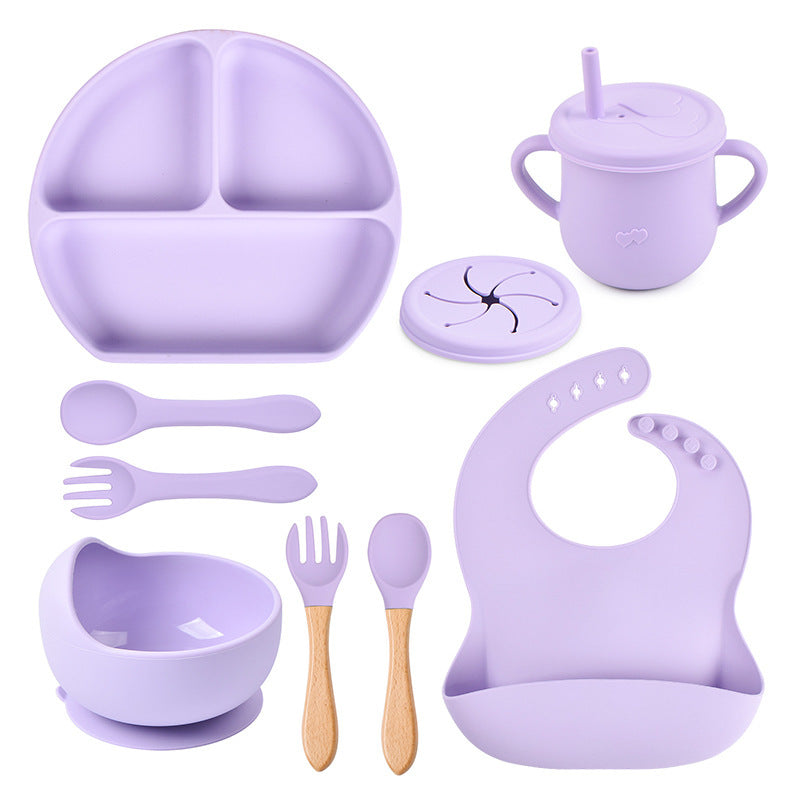 Purple children's dining set including bowl, spoon, fork, bib, and cup on a white background