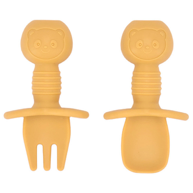 Two yellow bear-shaped utensils on a white background