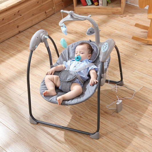 Baby in a gray baby swing on a wooden floor