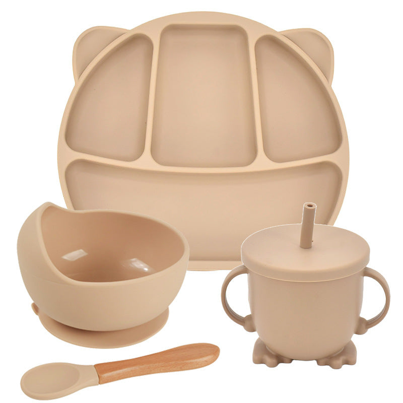 Beige children's tableware set including a plate, bowl, cup with straw, and spoon on a white background.