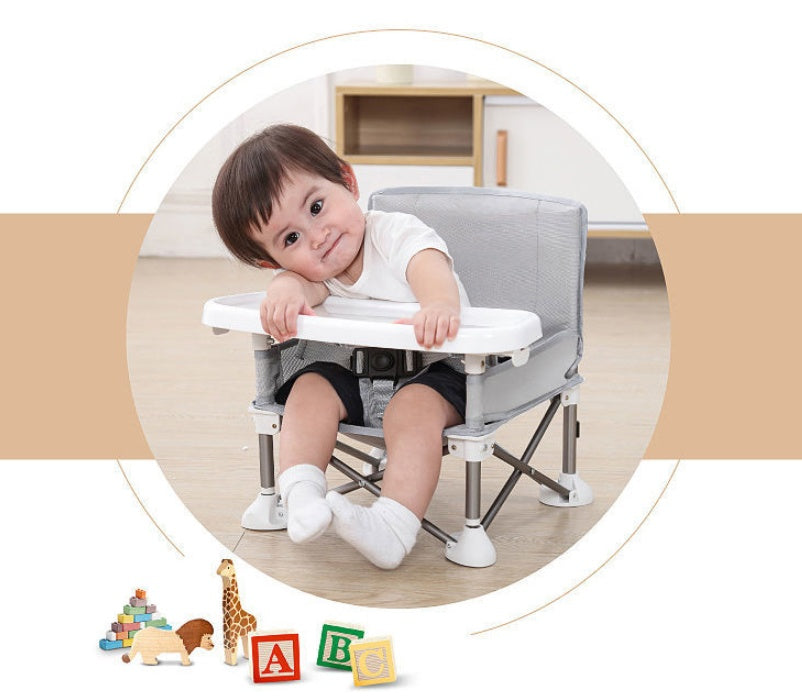 Child sitting in a portable chair with educational toys on the floor.