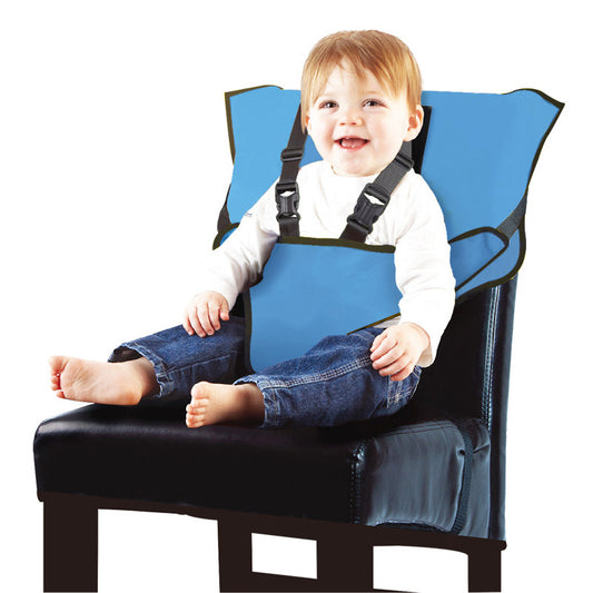 Child sitting in a blue booster seat on a black chair with a white background