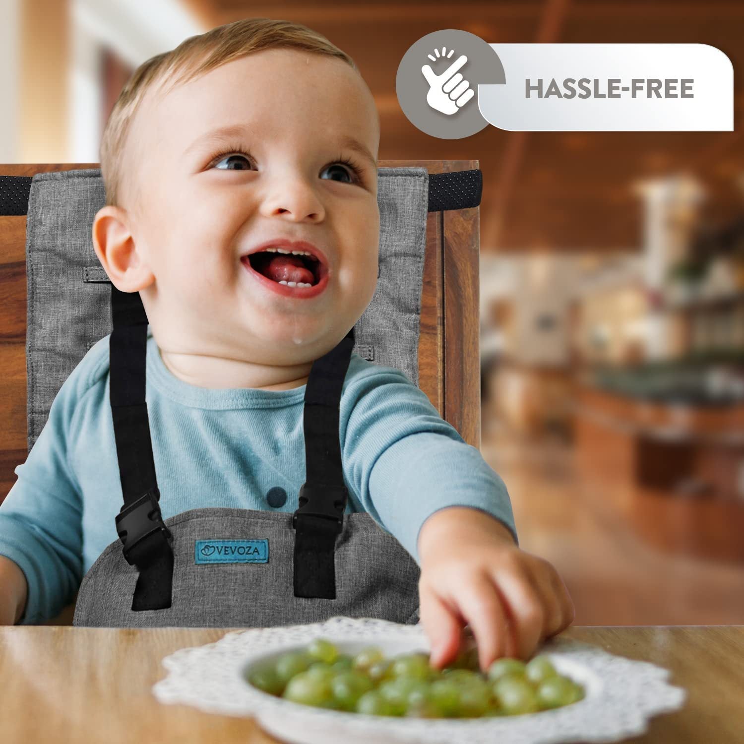 Child in a high chair with a bib, reaching for grapes on a plate, with a 'Hassle-Free' label above.