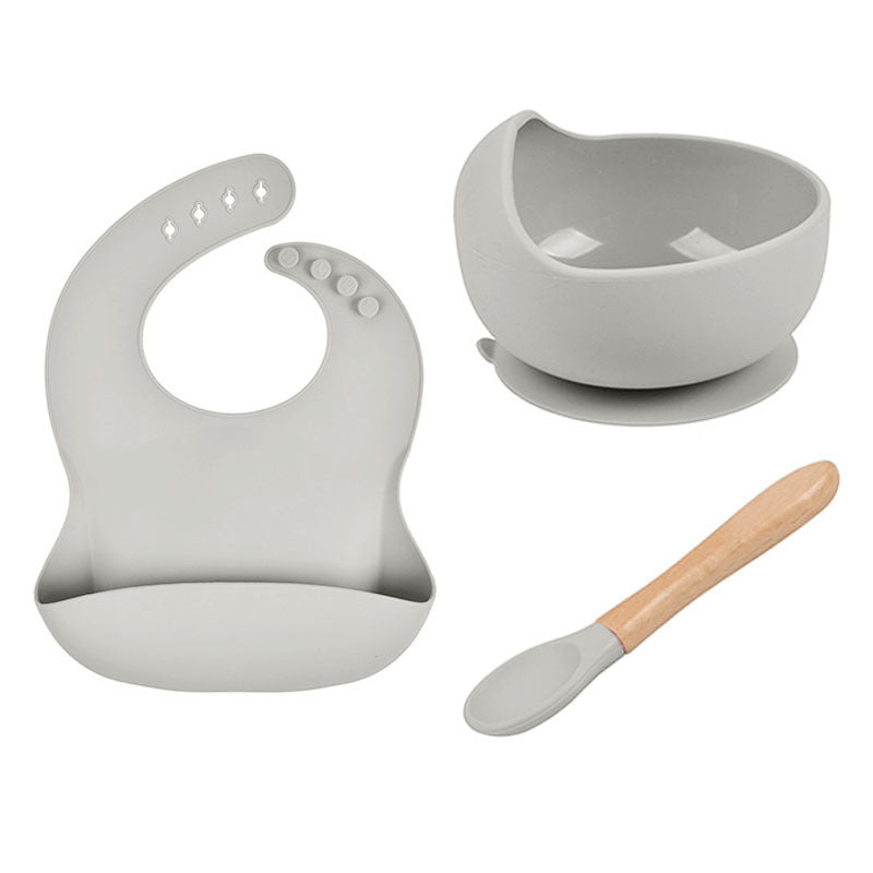 Gray baby bib, bowl, and spoon set on a white background