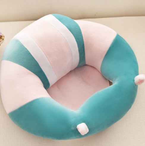Neck pillow with pink and teal stripes on a beige surface