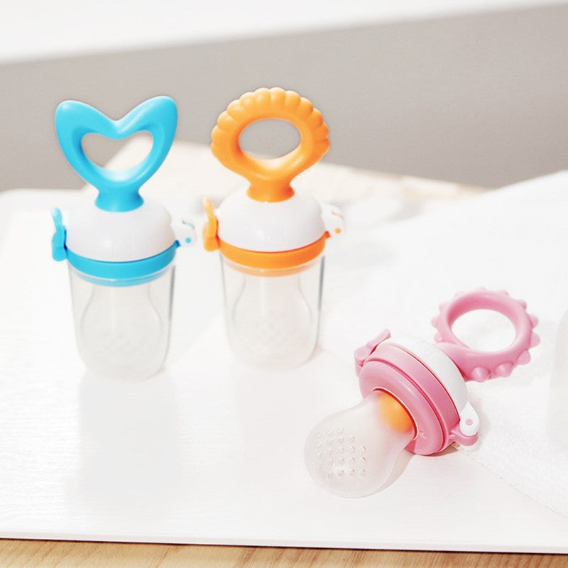 Three colorful baby pacifiers on a white surface.