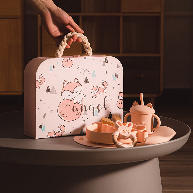 Children's toy set with a pink suitcase featuring fox illustrations on a dark surface.