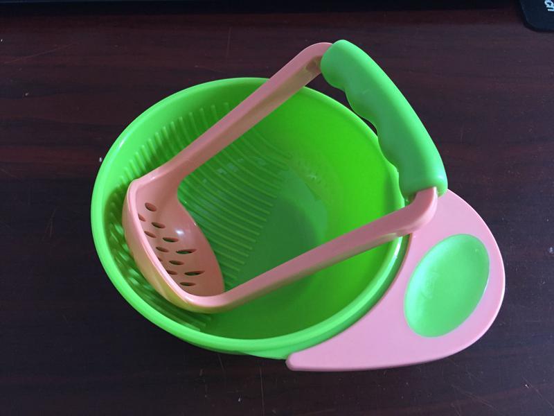 Green and pink kitchen tool on a dark surface