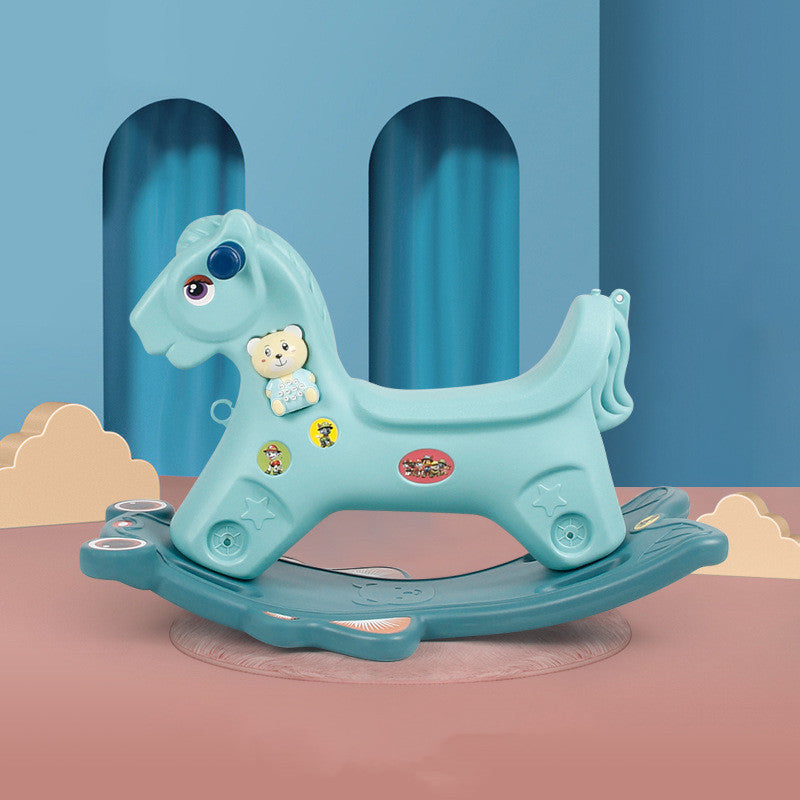 Blue rocking horse toy with stickers on a pink platform against a blue curtain background