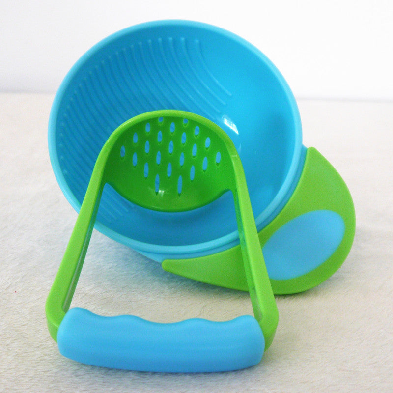 Blue and green plastic baby food processor on a white background
