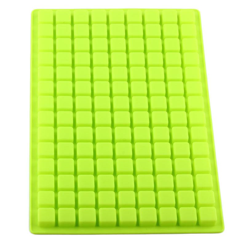Green silicone mold with small cavities on a white background