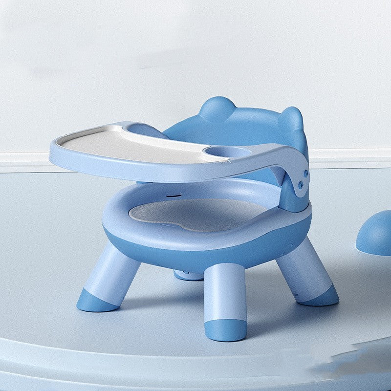 Blue children's potty chair with a seat and tray on a light gray background