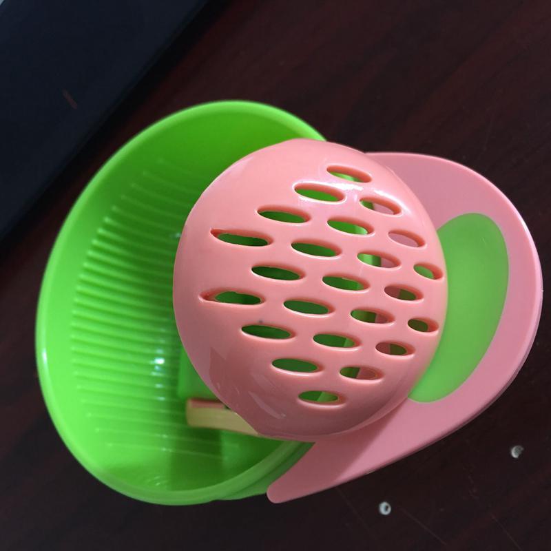 Pink and green kitchen tool on a dark surface