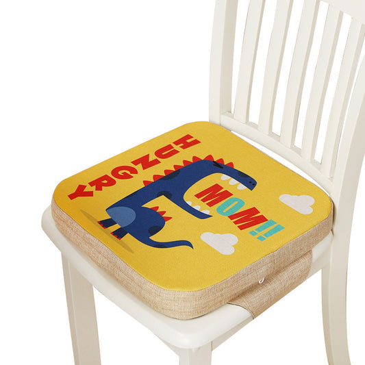 Yellow children's seat cushion with a dinosaur design and text on a white chair.