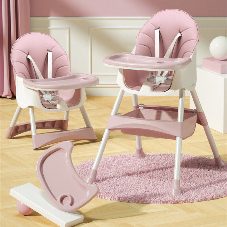 Pink and white high chair with additional tray on a wooden floor.