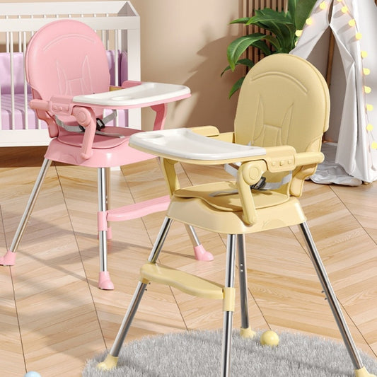 Two high chairs, one pink and one yellow, on a wooden floor.