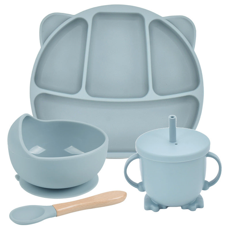 Set of blue silicone dining utensils including a plate, bowl, cup, and spoon on a white background.