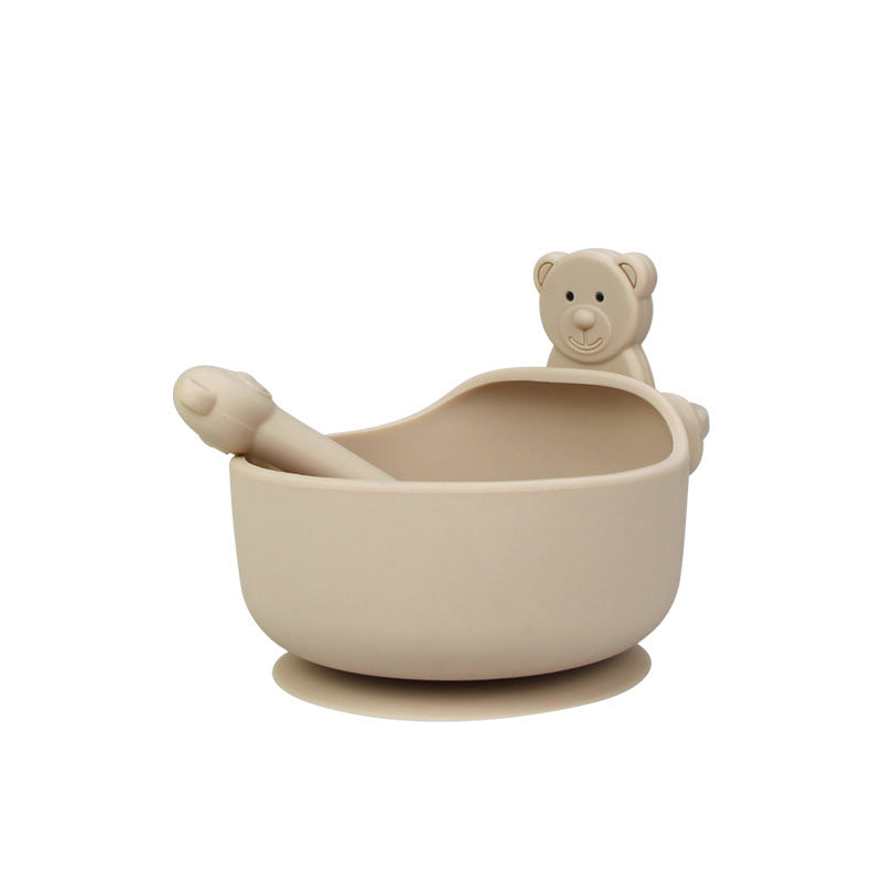 Beige bowl with a spoon and bear-shaped container on a white background