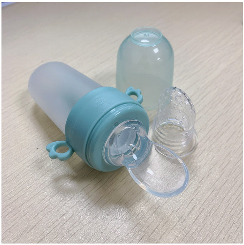 Blue and clear baby bottle with a detachable nipple on a light textured surface