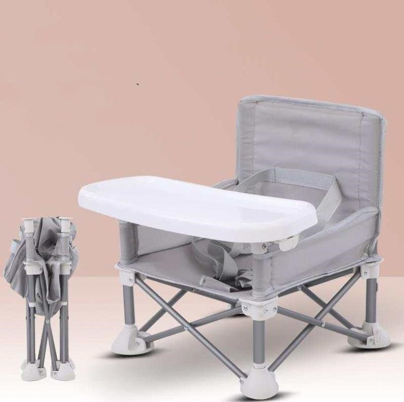 Gray and white folding chair with tray on a beige background