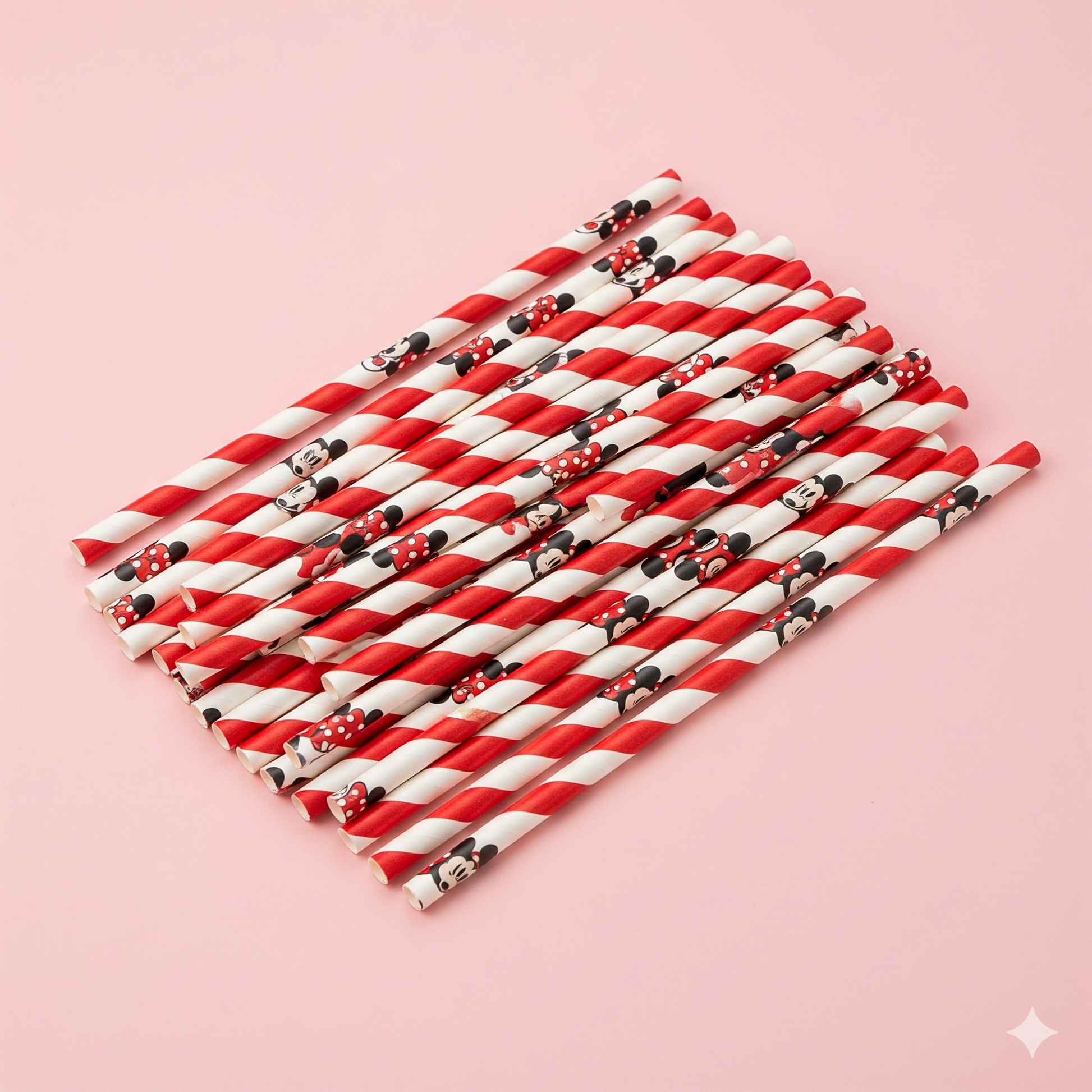 Red and white striped straws with Minnie Mouse design on a pink background