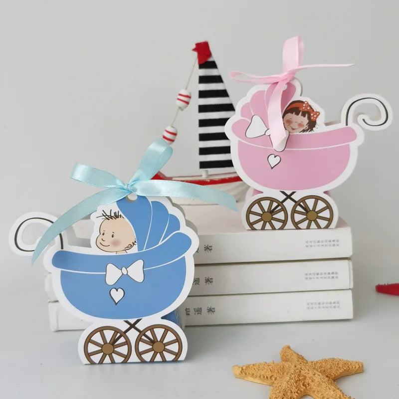 Two baby stroller-shaped decorations, one blue and one pink, on a stack of books with a starfish in the foreground.