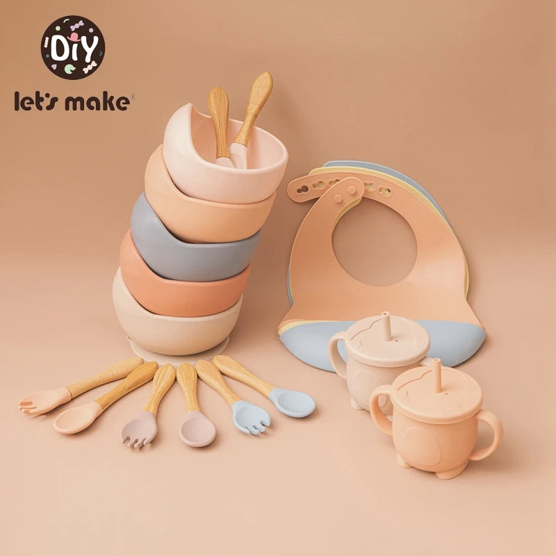Children's kitchenware set including bowls, cups, spoons, and a bib on a beige background with 'let's make' branding.