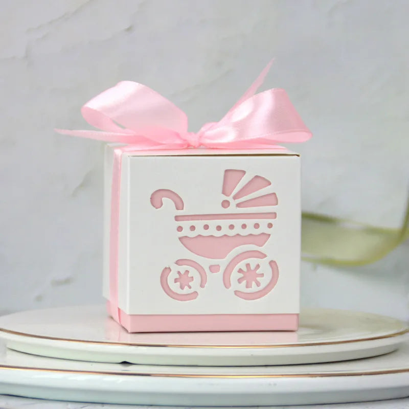 White gift box with pink baby carriage design and bow on a light background
