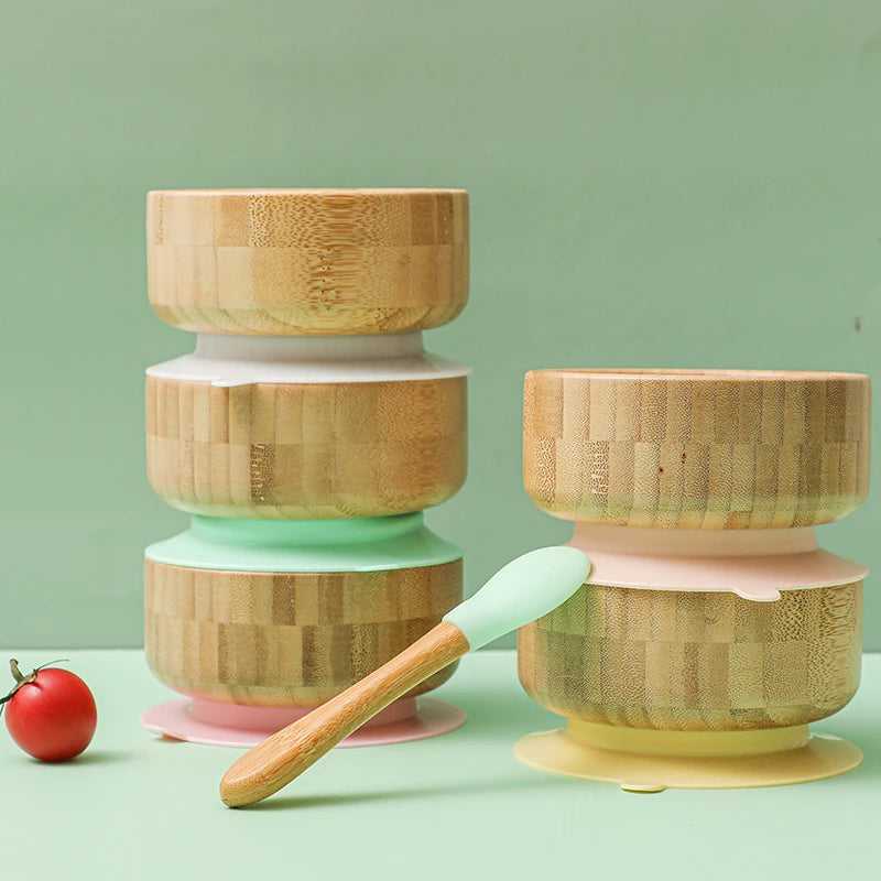 Set of bamboo containers with colorful bases on a green background