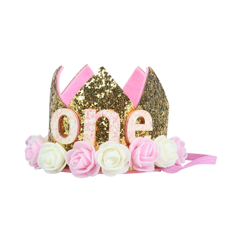 Gold glitter crown with pink accents and floral decorations on a white background