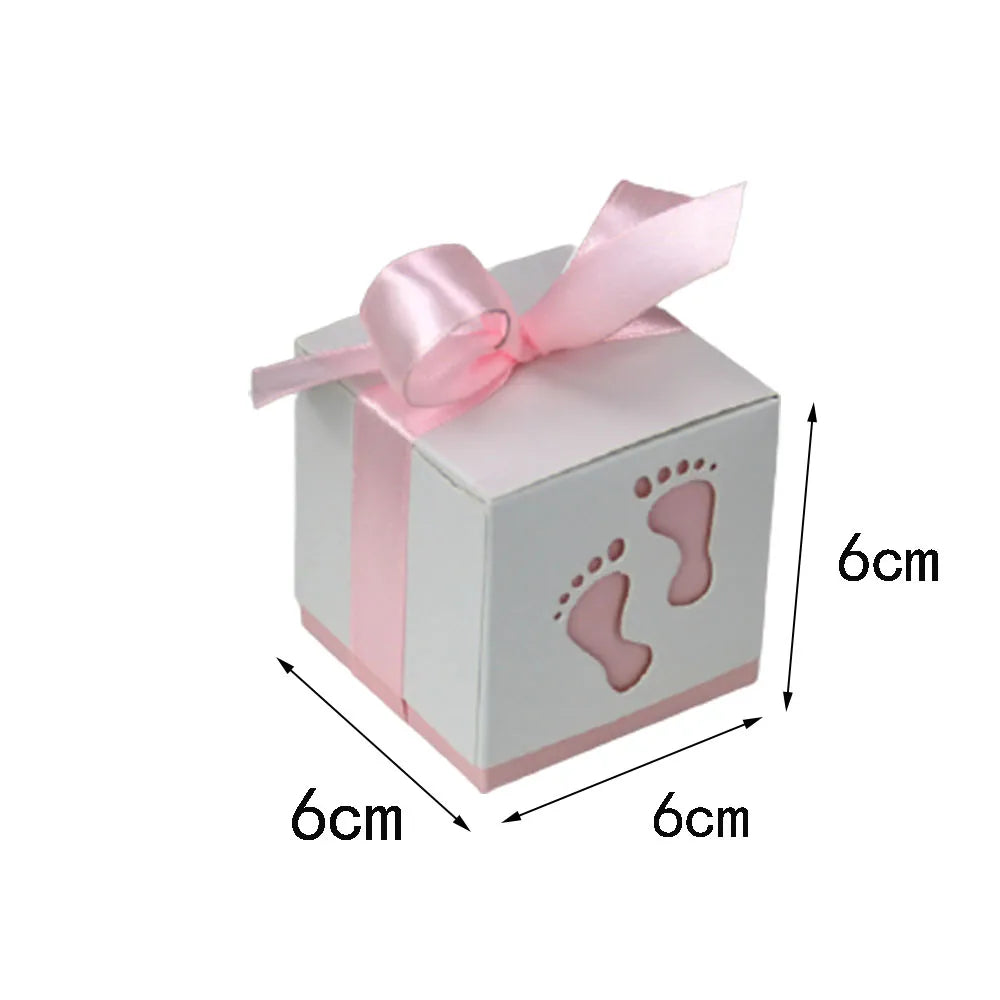 Small cube-shaped gift box with pink ribbon and footprints, dimensions indicated.