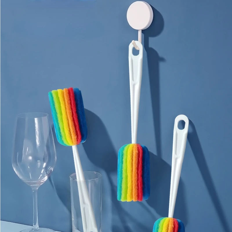 Set of rainbow-colored bottle brushes with a white holder on a blue background