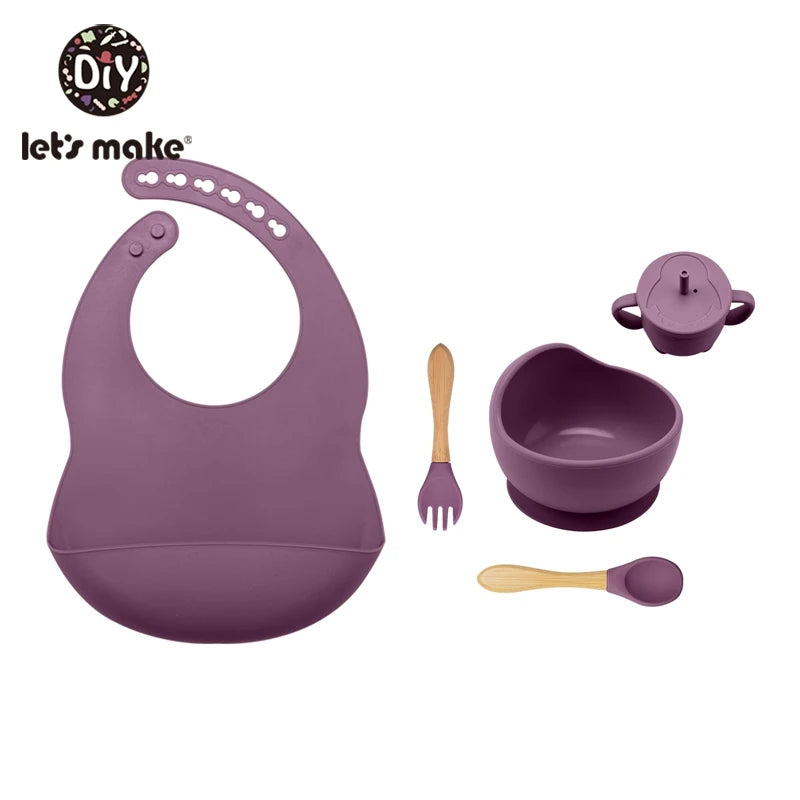 Purple baby bib, bowl, spoon, and fork set with 'let's make' branding on a white background