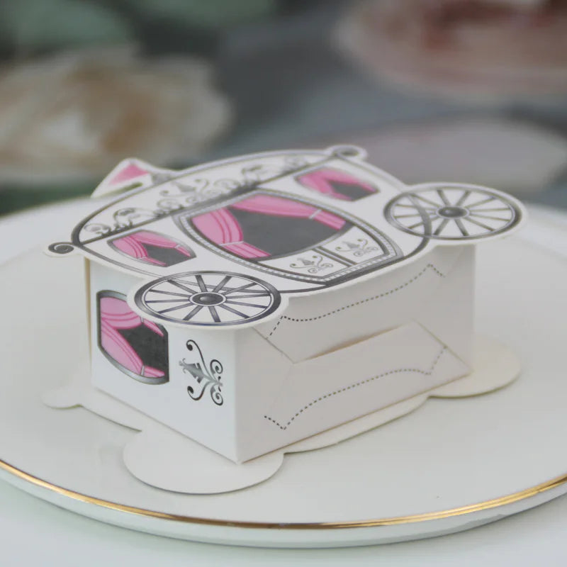 Decorative box shaped like a pink carriage on a white plate with gold rim