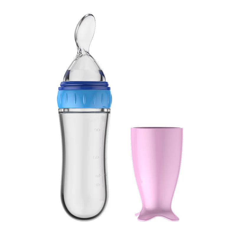 Clear baby bottle with blue cap and pink mermaid tail on a white background