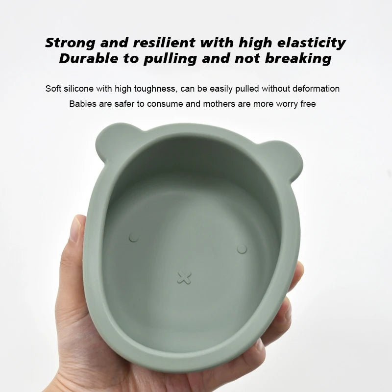 Silicone bowl with bear ears held by a hand on a white background