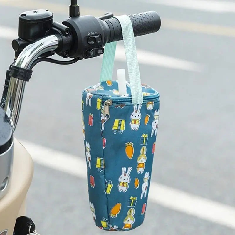 Blue insulated drink holder with cartoon design attached to a bicycle handlebar.