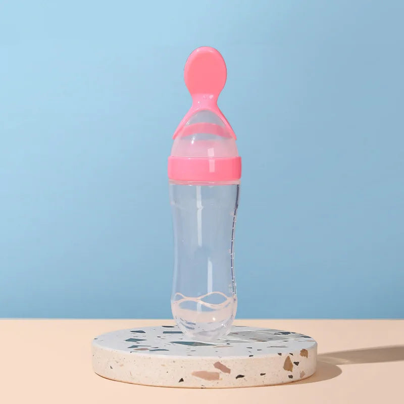 Pink and clear baby bottle on a terrazzo coaster with a blue background