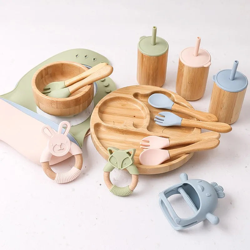 Set of wooden and silicone baby utensils and toys on a white background
