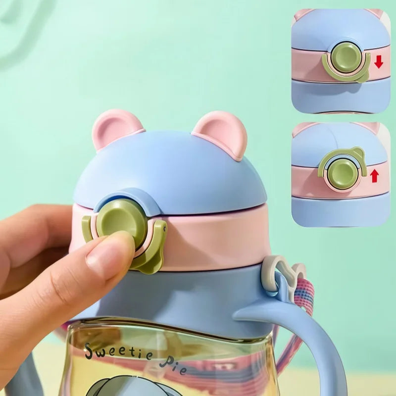 Colorful water bottle with bear-like design held by a hand against a light green background