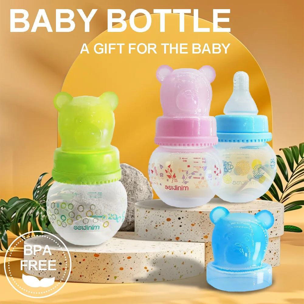 Set of colorful baby bottles with bear designs on a wooden block against a yellow background.